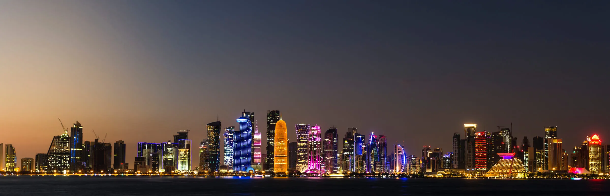 Doha, Qatar skyline at night as photographed from the Arabian Gulf, also known as the Persian Gulf.