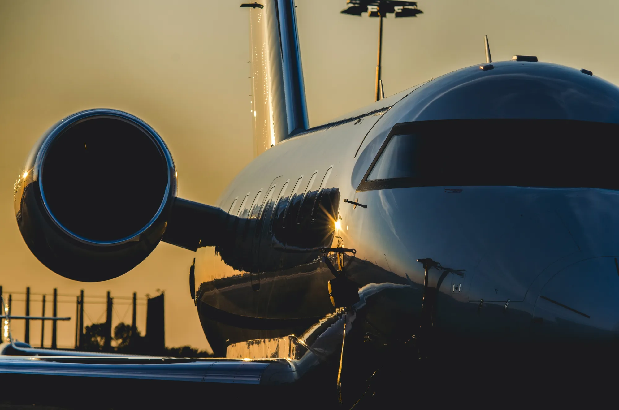 A jet being bathed in the glow of a sunset on the tarmac at Schipol airport.