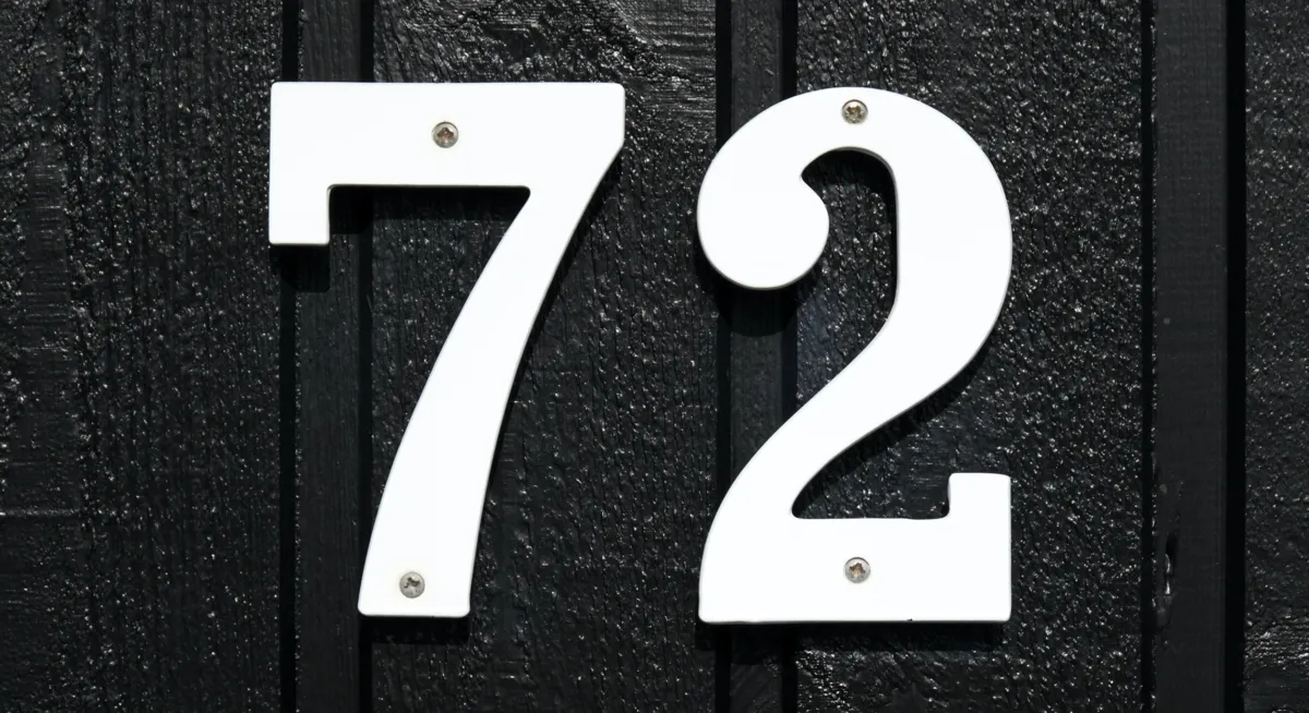 The digits 7 and 2 affixed to an exterior house wall.