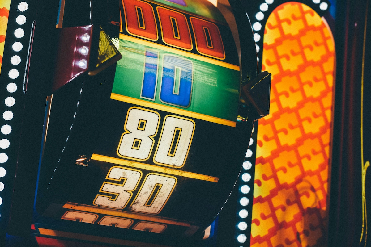 A fortune spinner wheel on a casino game that resembles the big spinner from the television game show, 'The Price is Right.' The wheel has landed on the '10' value, which has blue numbers against a green background. Other numbers are visible on the wheel, including one thousand, eighty, and thirty. Those numbers are white against a black background.
